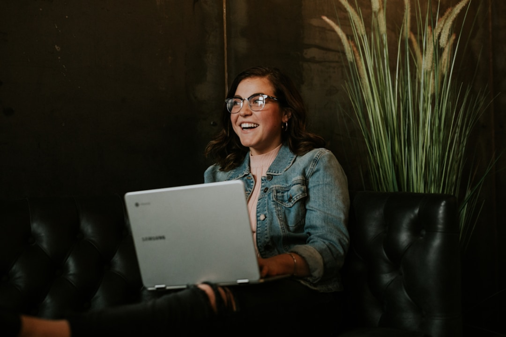 A woman smiling while using online faxing software, appreciating its enhanced security and compliance features.