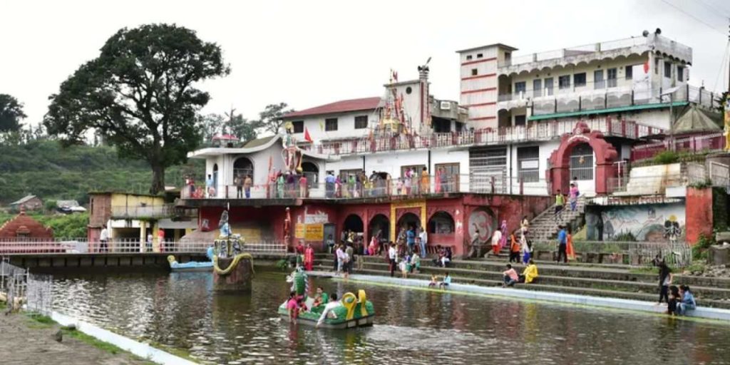 Chamunda Devi Temple ghat with devotees performing rituals near the river in Himachal Pradesh
