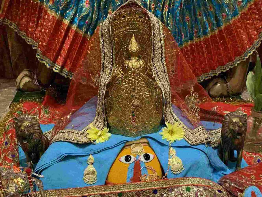 Sacred idol of Chintpurni Mata adorned with a golden crown, colorful garments, and traditional ornaments at Chintpurni Shakti Peeth, Himachal Pradesh.
