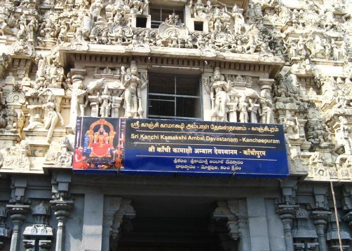 Tall white gopuram of Kamakshi Amman Temple with intricate sculptures in Kanchipuram.