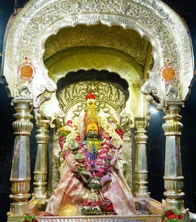 Tulja Bhavani idol beautifully decorated with flower garlands and gold ornaments inside the sanctum at Tuljapur