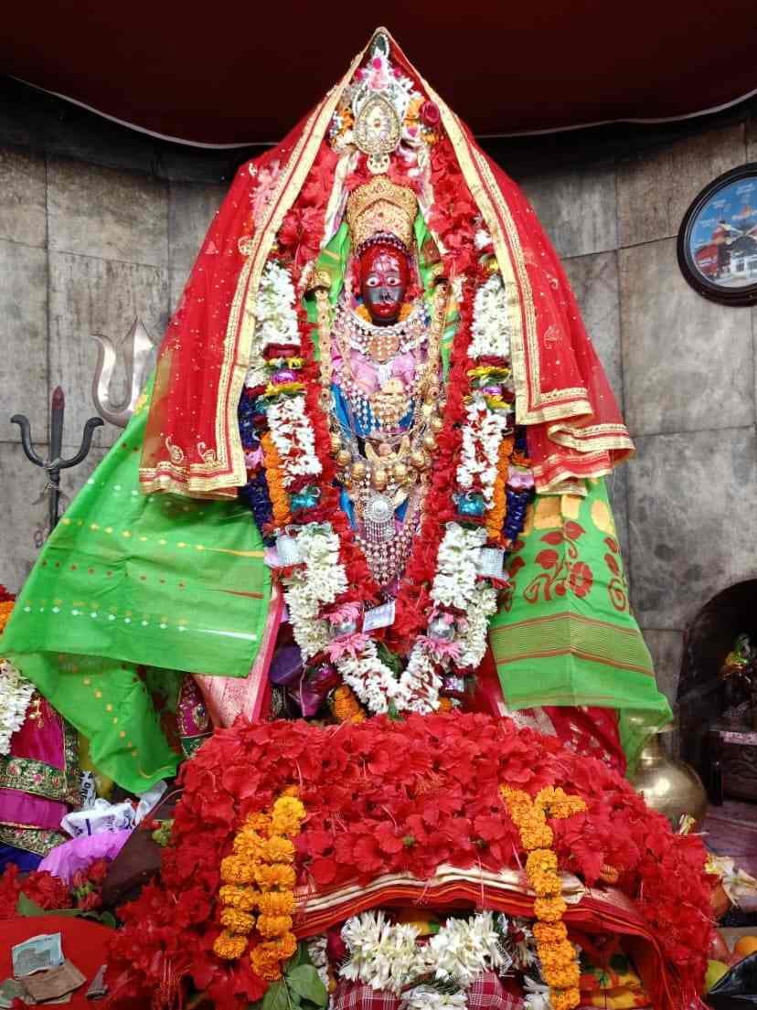 Tripura Sundari Mata idol decorated with gold ornaments and red flowers at Matabari Temple