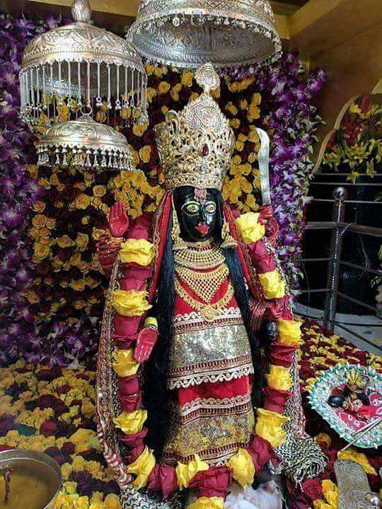 Decorated idol of Goddess Bhadrakali adorned with flowers and gold ornaments inside temple sanctum