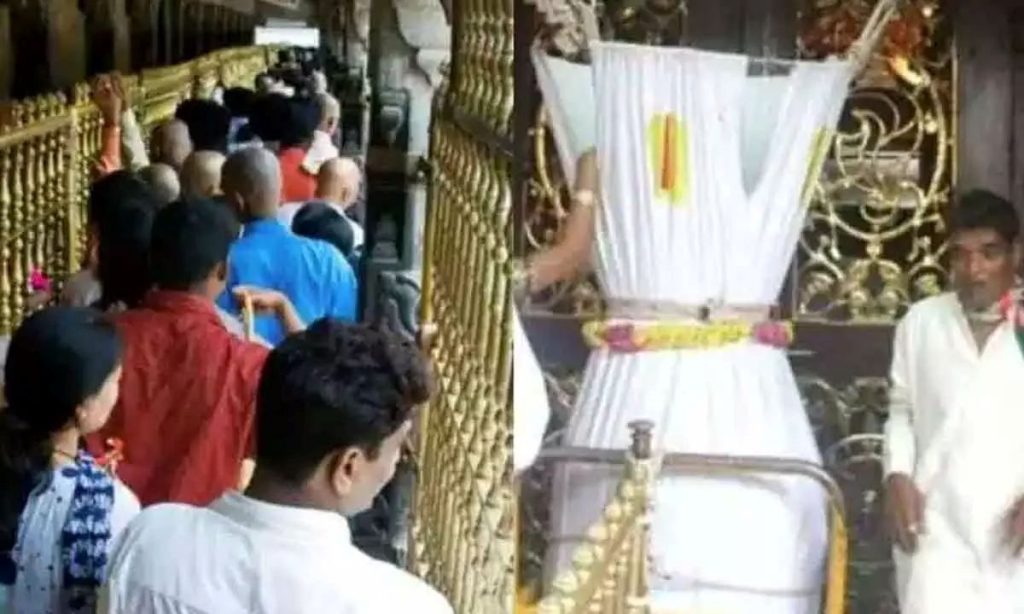 Devotees offering money and donations into the Tirumala temple hundi inside the Tirupati Balaji temple.
