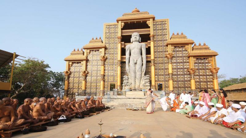 Bahubali statue at Dharmasthala with devotees and temple architecture in Karnataka