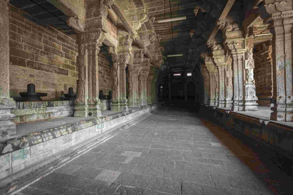 Ancient stone corridor with carved pillars inside Ekambareswarar Temple