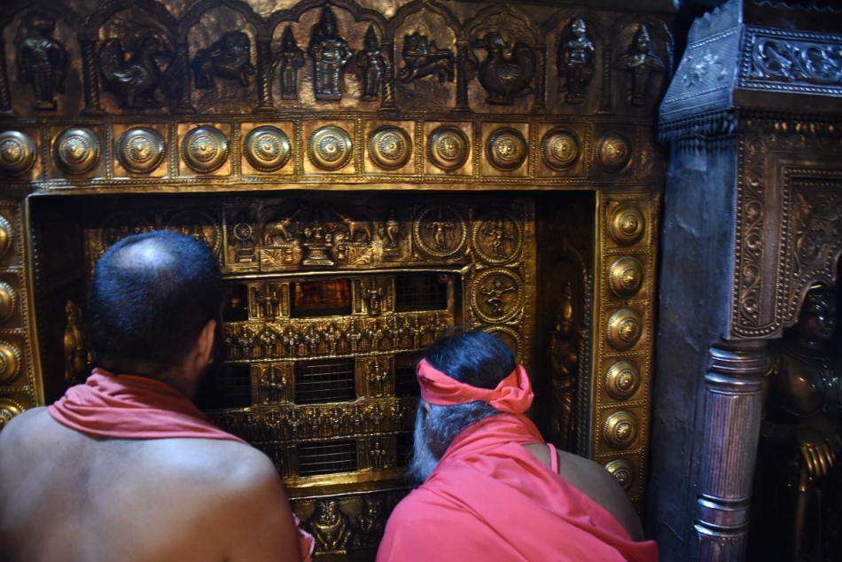 Devotees offering prayers through Kanakana Kindi window at Udupi Krishna Temple