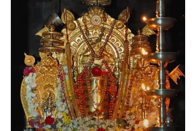 Shiva Linga of Lord Manjunatha decorated with flowers and lamps at Dharmasthala temple