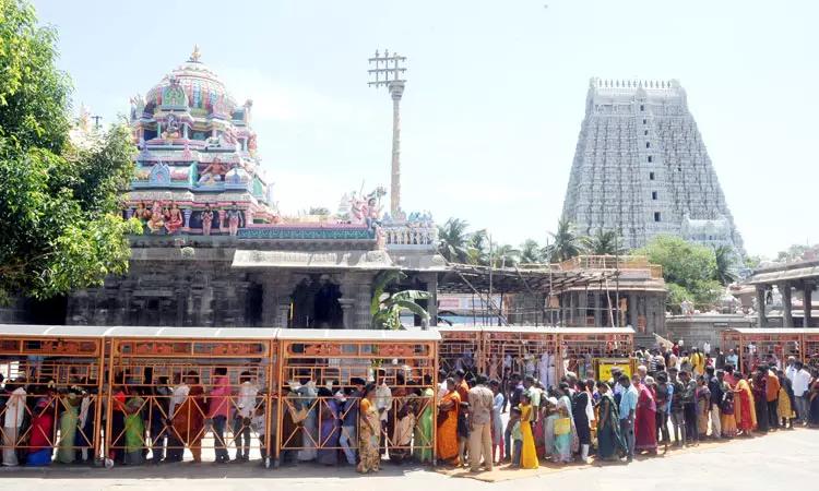Devotees standing in darshan queue at Arunachaleswarar Temple with towering gopuram in Tiruvannamalai