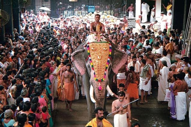 Elephant procession at Guruvayur Temple festival with large crowd of devotees